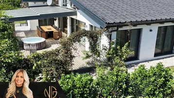 Vogelperspektive des modernen Hauses mit großer Holzterrasse, Whirlpool und Essbereich im Freien.