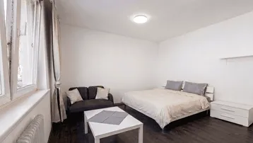 Helles Zimmer mit Bett, Sofa und Couchtisch, ideal für Wohnen und Schlafen.