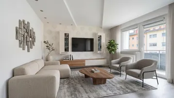 Helles Wohnzimmer mit modernem Design, bequemen Möbeln, großem Fenster und hohen Decken.