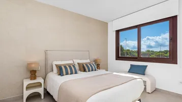 Geräumiges Hauptschlafzimmer mit Doppelbett, beiger Wand und großem Fenster mit weitem Blick.