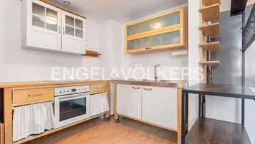 Funktionale Küche mit Holzschränken, Backofen und Spüle, ausgestattet für den täglichen Gebrauch.