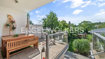Geräumige Terrasse mit Holzmöbeln und Blick ins Grüne, ideal für entspannte Stunden im Freien.