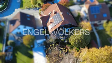 Luftaufnahme des Hauses mit Solarmodulen auf dem Dach und umgebender Vegetation.