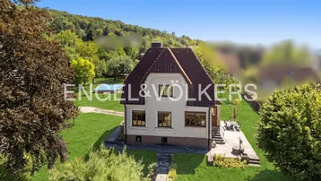 Luftaufnahme eines Einfamilienhauses mit großem Garten, Pool und viel Grün in ländlicher Umgebung.