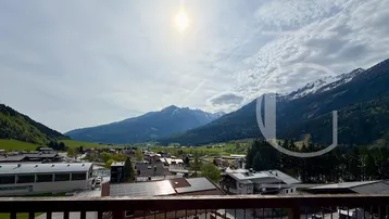 Panoramablick vom Balkon auf die umliegende Berglandschaft und das Tal.