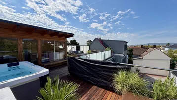 Geräumige Dachterrasse mit Whirlpool, Holzdeck und weitem Blick über die Umgebung.