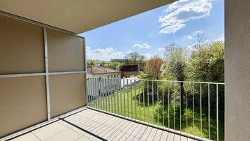 Heller Balkon mit Fliesenboden und weitem Blick ins Grüne und auf die Umgebung.