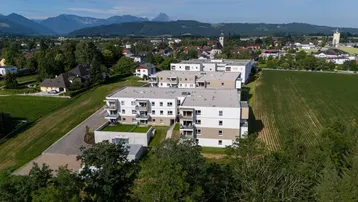 Weitläufige Luftaufnahme der Wohnanlage mit Blick auf die umliegende Landschaft und die Berge.
