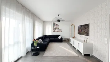 Helles Wohnzimmer mit großem Ecksofa, modernem TV-Möbel und gemusterten Tapeten.