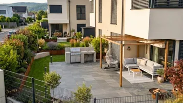 Moderne Terrasse mit Pergola, Grillbereich und gemütlicher Sitzecke in einem gepflegten Garten.