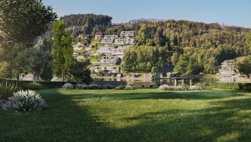 Gepflegte Rasenfläche mit weitem Blick auf den See und die bewaldeten Berghänge.