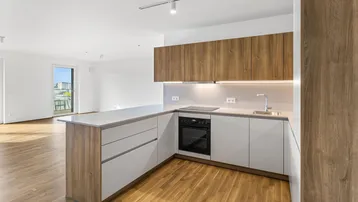 Moderne Einbauküche mit Holz- und weißen Fronten, integrierten Geräten und Zugang zum Balkon.