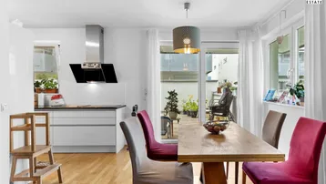 Heller offener Wohn- und Essbereich mit moderner Küche und Zugang zur Terrasse.