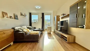 Helles Wohnzimmer mit Holzfußboden, bequemer Couch und modernem TV-Möbel.