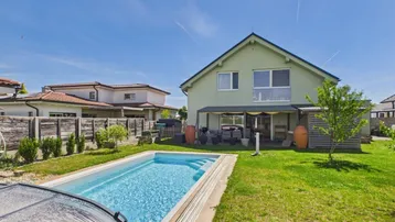 Großzügiger Gartenbereich mit privatem Pool und viel Grünfläche hinter dem modernen Wohnhaus.