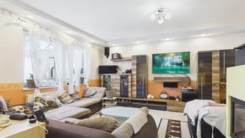 Gemütliches Wohnzimmer mit Kamin, großem Sofa und Unterhaltungselektronik.