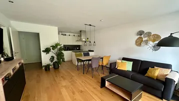 Offener Wohnbereich mit integrierter Küche, Holzboden und modernem Design.