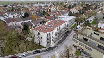 Luftaufnahme einer neuen Wohnanlage in einer städtischen Umgebung mit umliegenden Häusern.