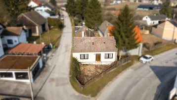 Luftaufnahme eines Einfamilienhauses mit Satteldach in ländlicher Umgebung.