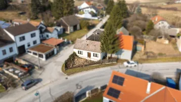 Weitwinkelaufnahme von oben zeigt das Haus und die umliegende Bebauung.