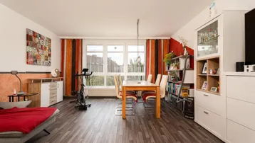 Geräumiger Wohn-Essbereich mit dunklem Laminatboden, großen Fenstern und viel Tageslicht.