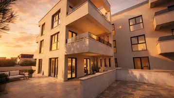 Moderne Wohnanlage mit stilvoller Architektur, großzügigen Terrassen und Balkonen im warmen Abendlicht.