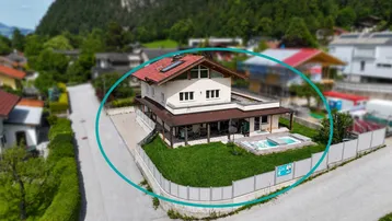 Luftaufnahme eines Einfamilienhauses mit gepflegtem Garten, Rasenfläche und integriertem Whirlpool.