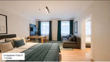 Helles Studio-Apartment mit Schlafbereich, Sofa und Esstisch, ausgestattet mit modernen Möbeln und Holzboden.