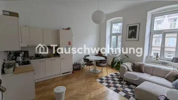 Helles, offenes Wohn-Esszimmer mit integrierter Küchenzeile und Fischgrätparkettboden.