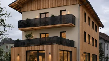 Modernes Gebäude mit Holzfassade, großen Glasflächen und mehreren Balkonen unter einem Satteldach.