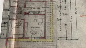 Detaillierter Grundriss des Erdgeschosses mit Wohnbereich, Küche, Schlafzimmer und Terrasse.