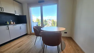 Moderne Küchenzeile mit kleinem Esstisch und Zugang zum sonnigen Balkon.
