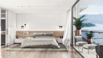 Helles Schlafzimmer mit Zugang zum Balkon und weitem Blick auf das Meer und die Berge.