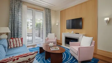 Helles Wohnzimmer mit modernem Kamin, Fernseher und Zugang zu einem Außenbereich.