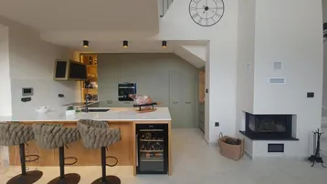 Offene Küche mit Kücheninsel, modernen Geräten und einem integrierten Kamin.