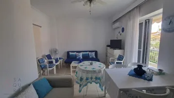 Geräumiger Wohn-Essbereich mit bequemen Sofas, Esstisch und Zugang zu einem Balkon.