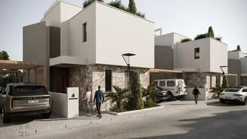 Moderne Reihenhäuser mit weißer Fassade, Steinelementen und begrünten Dächern in einer Wohnsiedlung.