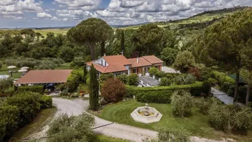 Luftaufnahme des Anwesens mit Haupthaus, weitläufigem Garten und umliegender Landschaft.