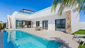 Moderne Villa mit großem Pool, Sonnenterrasse und Essbereich im Freien unter blauem Himmel.