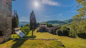 Panoramablick auf das historische Anwesen in ländlicher Umgebung mit einem Solarpaneel im Vordergrund.