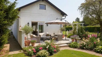 Charmante Terrasse mit Gartenmöbeln und üppiger Bepflanzung, ideal für entspannte Stunden im Freien.