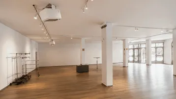 Großer, heller Gewerberaum mit modernem Laminatboden, hohen Decken und flexibler Beleuchtung.