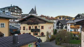 Malerische Ansicht einer traditionellen Alpenstadt mit charakteristischen Gebäuden und Kirchturm.