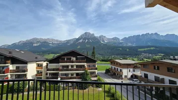 Panoramablick vom Balkon auf die majestätische Bergwelt und die umliegende Bebauung.