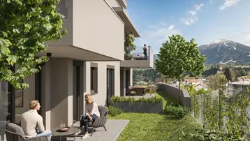 Moderne Wohnanlage mit Terrasse und Gartenbereich, umgeben von grüner Landschaft und Bergblick.