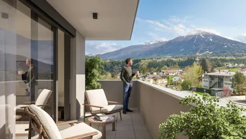 Mann genießt den Bergblick von einem möblierten Balkon mit modernen Fliesen und Glasfront.
