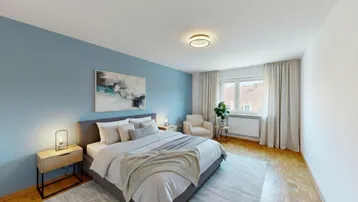 Modernes Schlafzimmer mit blauer Akzentwand, Parkettboden und großem Fenster, hell und einladend.