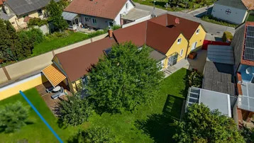 Luftaufnahme eines Einfamilienhauses mit großem Garten, Terrasse und Blick auf die ländliche Umgebung.
