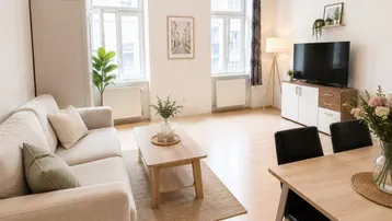 Helles Wohn- und Esszimmer mit Parkettboden, Holzbalkendecke und großen Fenstern, modern eingerichtet.