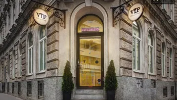 Historische Fassade eines Eckgebäudes mit großen Bogenfenstern und einem modernen Eingangsbereich.